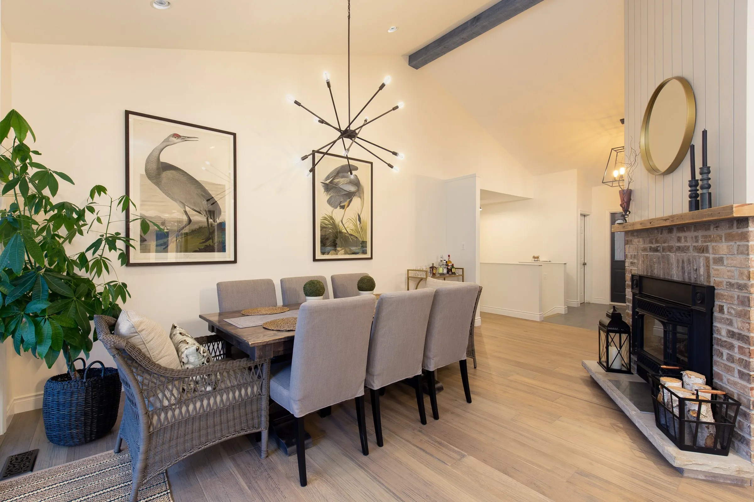 Dining room with a brick fireplace and modern chandelier