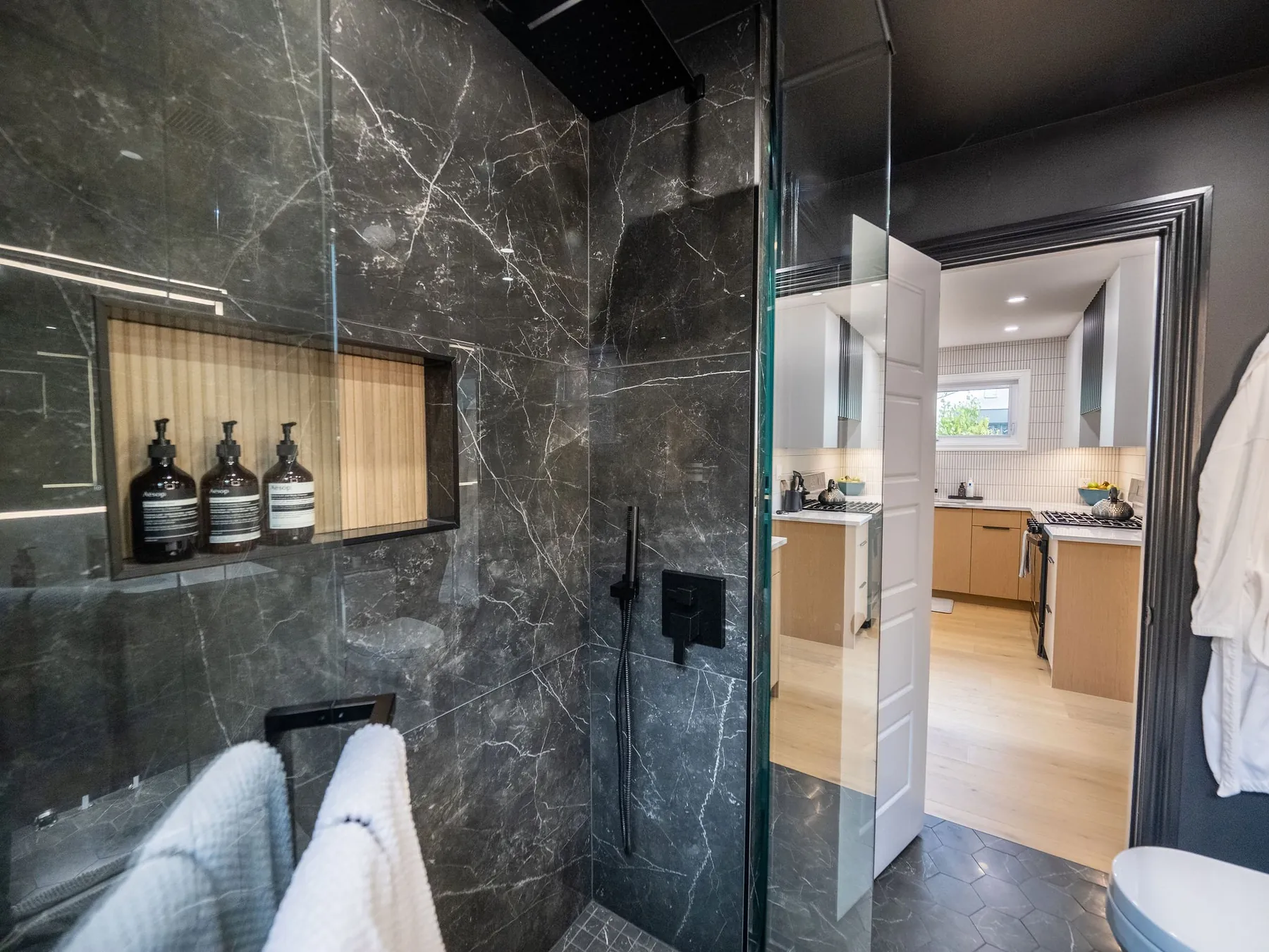 Dark marble walk-in shower with a niche