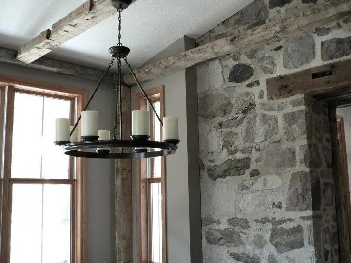 Dining area with a stone wall and chandelier